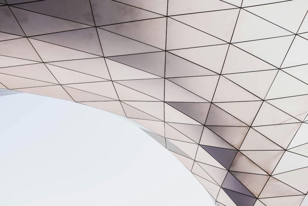 Abstract architectural detail showcasing a geometric pattern with triangles under natural light.